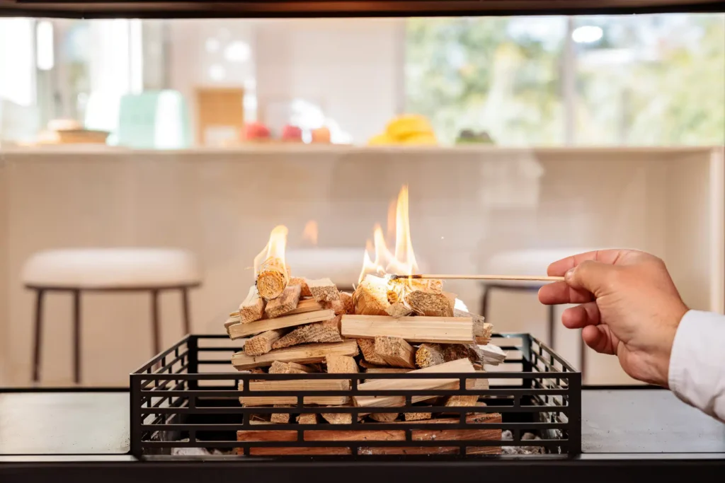 Allumage d’une cheminée design avec bûches empilées dans un intérieur contemporain – Cheminées Nicolas
