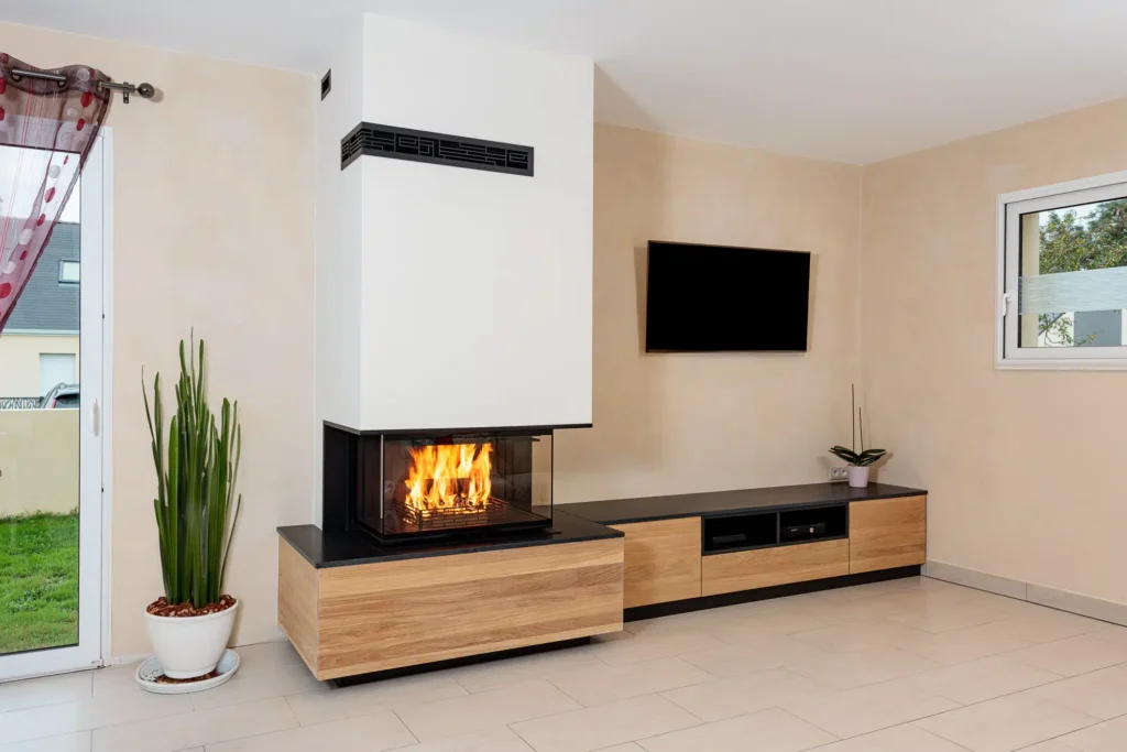 Cheminée sur-mesure Rüegg RIII avec habillage en chêne massif et banc TV intégré, conçue par Cheminées Nicolas à Cordemais.