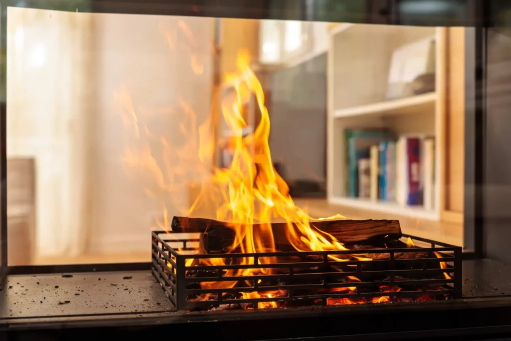 Gros plan sur un feu de bois dans un foyer Rüegg Violino installé par Cheminées Nicolas, mettant en valeur une combustion propre et performante.