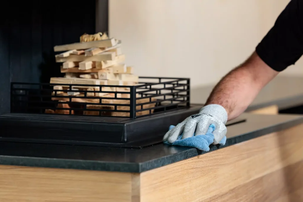 Entretien du plateau en granit noir Zimbabwe finition cuir d'une cheminée sur-mesure installée par Cheminées Nicolas.