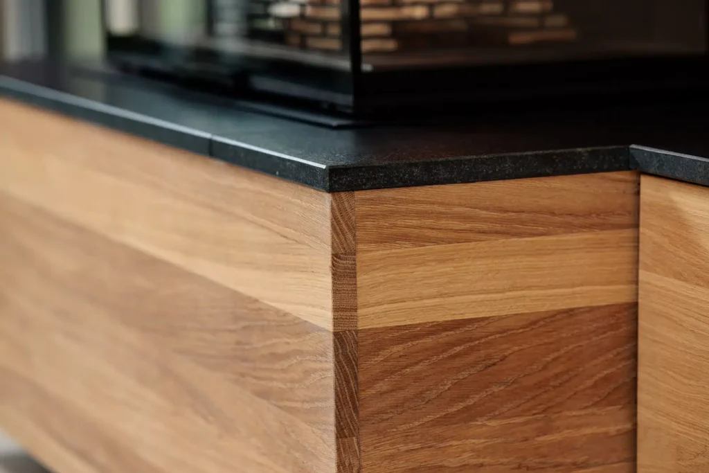 Détail de l'assemblage de l'habillage en chêne massif sur-mesure pour une cheminée Rüegg, réalisation artisanale Cheminées Nicolas.